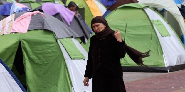 ATHENS, GREECE - APRIL 01: A refugee woman walks past tents at Piraeus port near Athens, Greece on April 01, 2016. More than five thousand refugees in Piraeus suffer from harsh living conditions. Refugees' 'journey of hope' towards Western European countries where they dream of having a better life ends in the Balkans following the latest decision. (Photo by Ayhan Mehmet/Anadolu Agency/Getty Images)