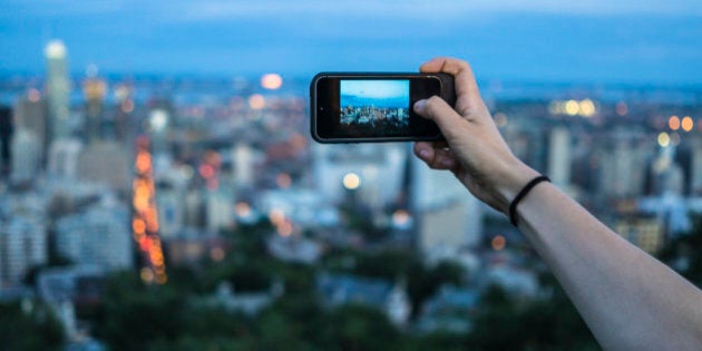 Woman taking photograph on hill, Le Plateau, Montreal, Quebec, Canada