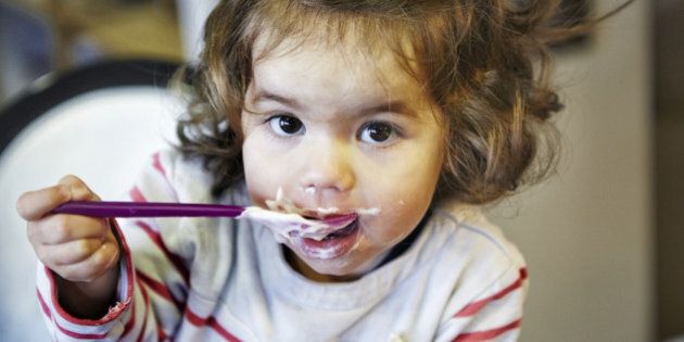 Young girl (18 months) eating yoghurt