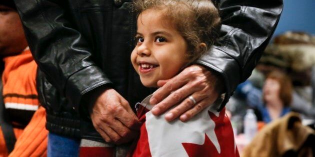 TORONTO, ON - DECEMBER 27: MAIN ART Reemas Al Abdullah, 5, gets a hug from her father Abdullah Al Abdullah prior to a dinner hosted by Friends of Syria at the Toronto Port Authority. (Bernard Weil/Toronto Star via Getty Images)
