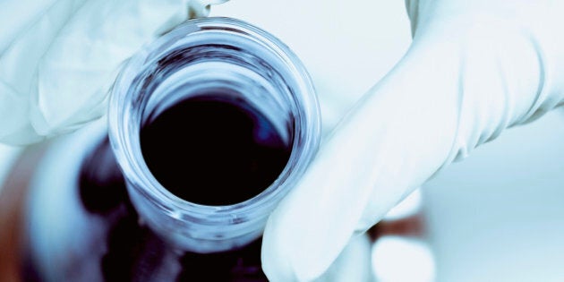 Close-up of a scientist's hand holding a flask