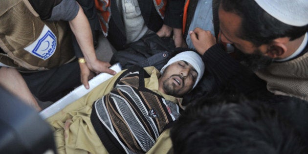 Pakistani paramedics transport a bomb blast victim to a hospital in Peshawar on December 29, 2015. At least 21 people were killed and dozens wounded when a Taliban suicide bomber on a motorbike crashed into the main gate of a government office in the northwest Pakistan town of Mardan, officials said. AFP PHOTO / Hasham AHMED / AFP / HASHAM AHMED (Photo credit should read HASHAM AHMED/AFP/Getty Images)