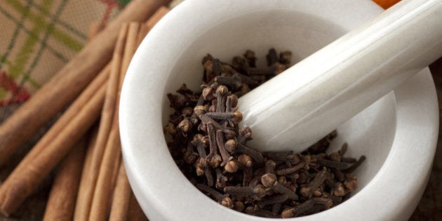 Fruit with spices in pestle and mortar