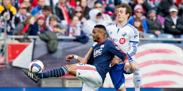 FOXBOUROUGH, MA - MARCH 20: New England Revolution Darrius Barnes clears the ball with pressure from Montreal Impact Cameron Porter during first half action of the MLS Opening Day at Gillette Stadium on Saturday, March 20, 2015. (Photo by Matthew J. Lee/The Boston Globe via Getty Images)