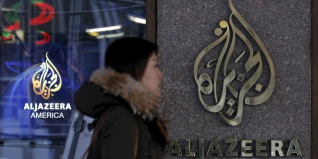 A woman passes by the Al Jazeera America broadcast center in midtown Manhattan in New York City January 13, 2016. Al Jazeera America, the cable television news outlet owned by Qatar-based Al Jazeera Media Network, is shutting down less than three years after its high-profile launch, the network said on Wednesday. REUTERS/Brendan McDermid TPX IMAGES OF THE DAY