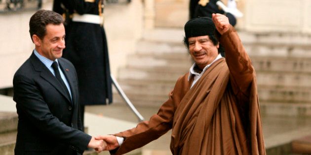 France's President Nicolas Sarkozy (L) greets Libyan leader Muammar Gaddafi in the courtyard of the Elysee Palace in Paris as he arrives for a five day official visit December 10, 2007. REUTERS/Jacky Naegelen (FRANCE)