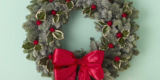 holiday wreath over mantel on green wall
