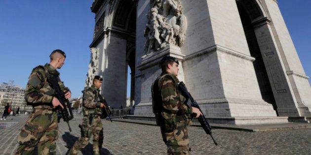 French soldiers patrol at the Arch of Triumph in the Champs Elysees district of Paris, France, Sunday, Nov. 15, 2015. Thousands of French troops deployed around Paris on Sunday and tourist sites stood shuttered in one of the most visited cities on Earth while investigators questioned the relatives of a suspected suicide bomber involved in the country's deadliest violence since World War II. (AP Photo/Amr Nabil)