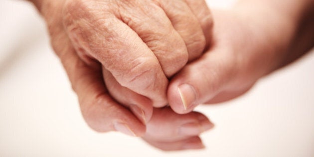 adult helping senior in hospital