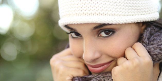 Beautiful arab woman portrait warmly clothed with an unfocused green background