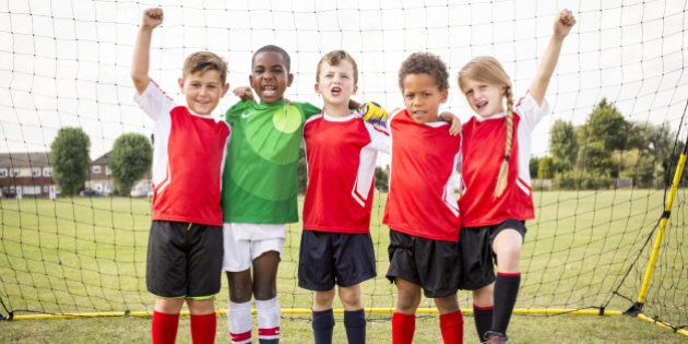 Five children standing in football goal