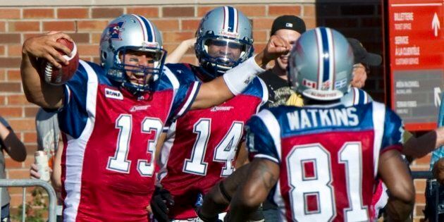 Montreal Alouettes quarterback Anthony Calvillo celebrates after scoring a touchdown against the Toronto Argonauts with teammates Brandon London, rear, and Kerry Watkins, right, during third quarter CFL football action Monday, October 10, 2011 in Montreal. (AP Photo/The Canadian Press, Paul Chiasson)
