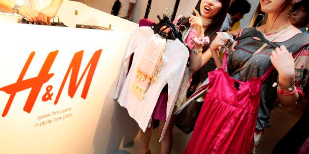 Shoppers on opening day of H&M's first Japan store in Tokyo's Ginza shopping district examine clothes Saturday, Sept. 13, 2008. H&M is arriving in Japan, seeking to woo a nation of notoriously finicky luxury-lovers with the same cheap prices that have made the Swedish fashion retailer a hit in the U.S. and Europe. (AP Photo/Itsuo Inouye)