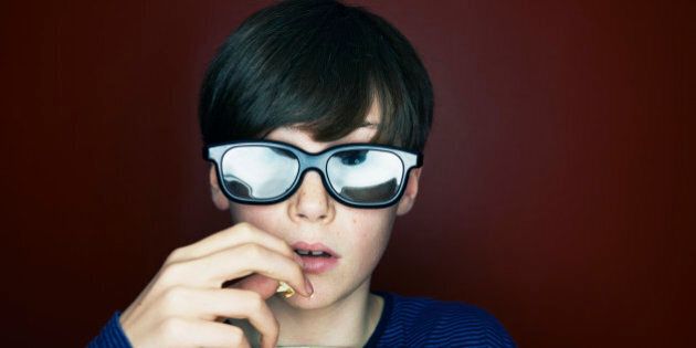 boy with 3d glasses and popcorn looking amazed