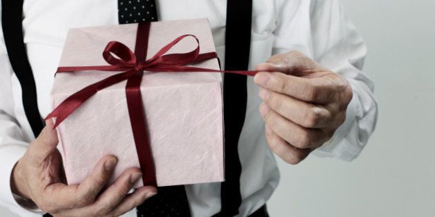 old age businessman pulling a ribbon of the gift