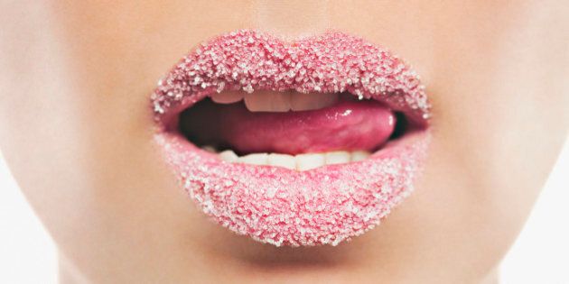 Close up of woman with pink lipstick licking sugar covered lips
