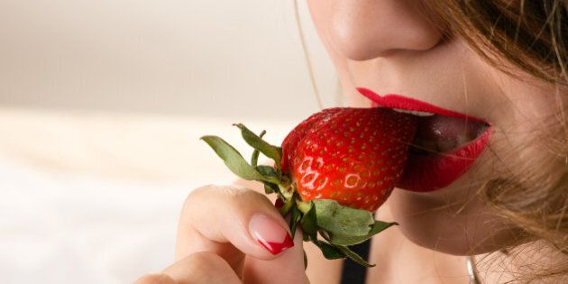 sensual woman eating strawberry closeup