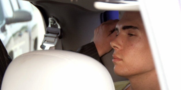 In this photo provided by Montreal Police, Luka Rocco Magnotta is guided into a waiting van after arriving from a Canadian military plane on Monday, June 18, 2012, in Mirabel, Quebec. Magnotta, the suspect in the killing and dismemberment of a Chinese student is on his way back to Canada via military transport from Germany, where he was arrested this month. (AP Photo/Montreal Police)