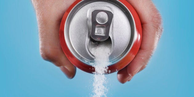 hand holding soda can pouring a crazy amount of sugar in metaphor of sugar content of a refresh drink isolated on blue background in healthy nutrition, diet and sweet addiction concept