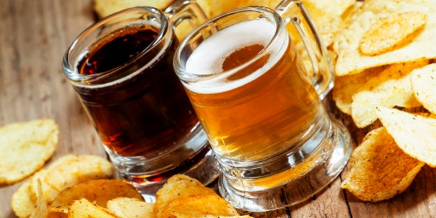 Dark and light beer and chips on the old wooden background, selective focus