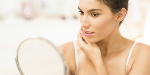 Caucasian woman admiring herself in mirror