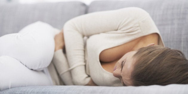 Feeling bad young woman laying on sofa