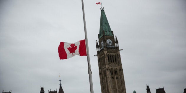 OTTAWA, ON - OCTOBER 23: A flag next to the Canadian Parliament Building is flown at half staff one day after Cpl. Nathan Cirillo of the Canadian Army Reserves was killed while standing guard in front of the National War Memorial by a lone gunman, on October 23, 2014 in Ottawa, Canada. After killing Cirillo the gunman stormed the main parliament building, terrorizing the public and politicians, before he was shot dead. (Photo by Andrew Burton/Getty Images)