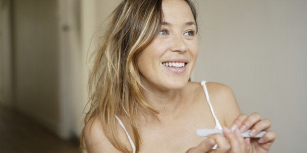 Woman filing nails with nail file, smiling