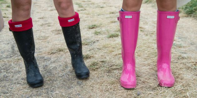 GLASTONBURY, ENGLAND - JUNE 26: Festival goers wear wellington boots in preparation for rain during the Glastonbury Festival at Worthy Farm on June 26, 2014 in Glastonbury, England. (Photo by Ian Gavan/Getty Images)