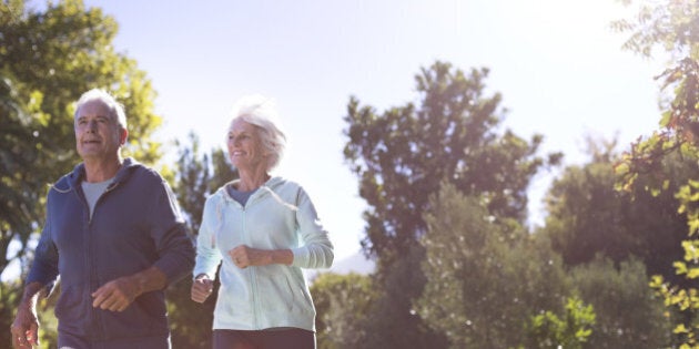Senior couple running in park