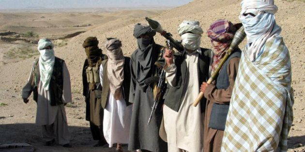 Face-covered militants who they say are Talibans, pose with RPG and AK47 in Zabul province, southern of Kabul, Afghanistan Saturday, Oct. 7, 2006. A Taliban commander said in a sit-down interview that insurgent fighters will battle