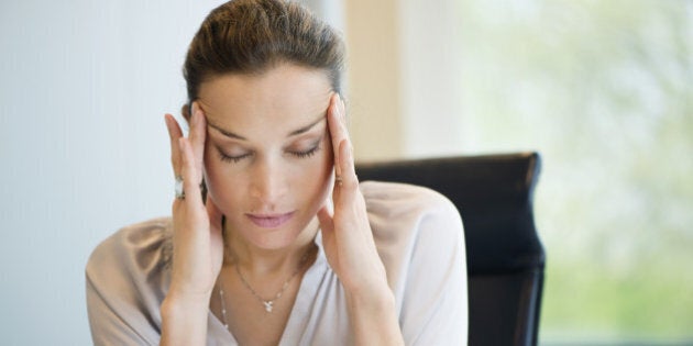 Close-up of a businesswoman suffering from a headache in an office