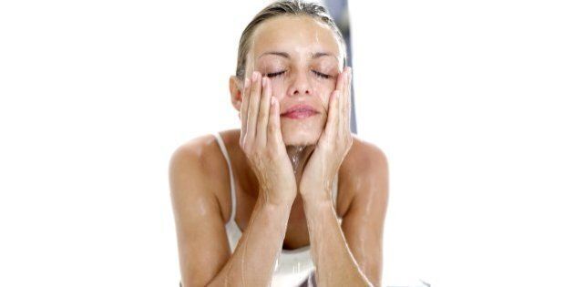 portrait of a woman washing her face with water
