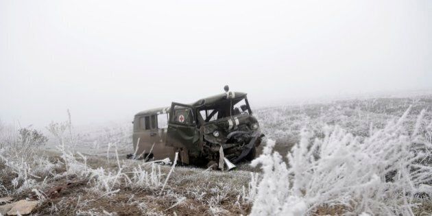An army ambulance destroyed in recent shelling between Russian-backed separatists and Ukrainian government forces lays by the road near the town of Svitlodarsk, Ukraine, Sunday, Feb. 15, 2015. A cease-fire was declared in eastern Ukraine, kindling slender hopes of a reprieve from a conflict that has claimed more than 5,300 lives. (AP Photo/Petr David Josek)