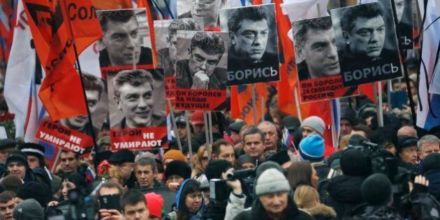 People march in memory of opposition leader Boris Nemtsov, who was gunned down on Friday, Feb. 27, 2015, with portraits of him and words read ' he died for the future of Russia, heroes never die!', near the Kremlin in Moscow, Russia, Sunday, March 1, 2015. Russian investigators, politicians and political commentators on state television on Saturday covered much ground in looking for the reason Nemtsov was gunned down in the heart of Moscow, but they sidestepped one possibility, that he was murdered for his relentless opposition to Putin. (AP Photo/Dmitry Lovetsky)