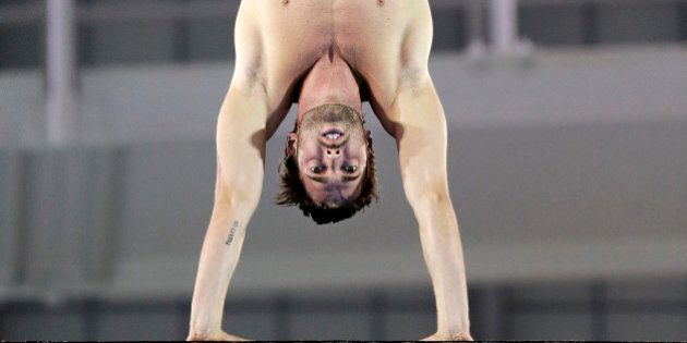 Maxim Bouchard of Canada prepares to dive during the preliminary round of the men's 10-meter platform event at the Pan Am Games Sunday, July 12, 2015, in Toronto. (AP Photo/Mark Humphrey)