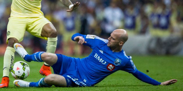 MEXICO CITY, MEXICO - APRIL 22: Michael Arroyo of America fights for the ball with Laurent Ciman of Montreal Impact during a Championship first leg match between America and Montreal Impact as part of CONCACAF Champions League 2014 - 2015 at Azteca Stadium, on April 22, 2015 in Mexico City, Mexico. (Photo by Miguel Tovar/LatinContent/Getty Images)
