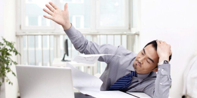 A businessman throwing document in office