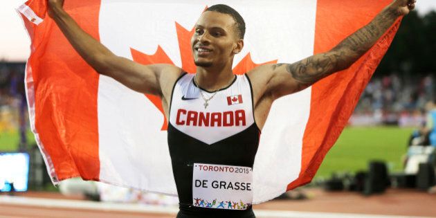 Canada's Andre De Grasse celebrates with a Canadian flag after winning the gold medal in the men's 100 meter race at the Pan Am Games Wednesday, July 22, 2015, in Toronto. (AP Photo/Mark Humphrey)