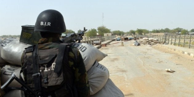 A picture taken on February 17, 2015 shows a Cameroonian soldier standing post in the Cameroonian town of Fotokol, on the border with Nigeria, after clashes occurred on February 4 between Cameroonian troops and Nigeria-based Boko Haram insurgents. Nigerian Boko Haram fighters went on the rampage in the Cameroonian border town of Fotokol on February 4, massacring dozens of civilians and torching a mosque before being repelled by regional forces AFP PHOTO / REINNIER KAZE (Photo credit should read Reinnier KAZE/AFP/Getty Images)