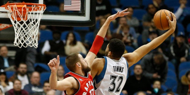 Minnesota Timberwolves center Karl-Anthony Towns (32) stretches out to shoot the ball against Toronto Raptors center Jonas Valanciunas (17) in the second half of an NBA basketball game Wednesday, Feb. 10, 2016, in Minneapolis. The Wolves won 117-112. (AP Photo/Stacy Bengs)