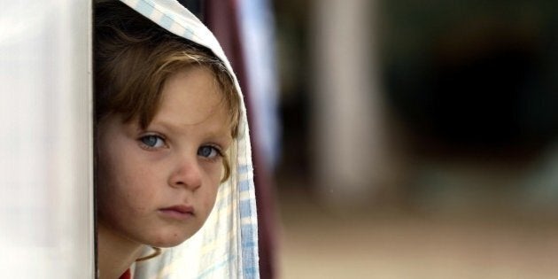 BEIRUT, LEBANON - NOVEMBER 19: A kid looks out through their tent at the Beqaa Valley refugee camp in Beirut, Lebanon on November 19, 2015. (Photo by Ratib Al Safadi/Anadolu Agency/Getty Images)