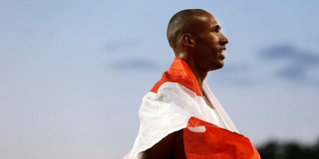Decathlon champion Damian Warner of Canada wears a national flag following his win in the men's decathlon 1500 meter run at the Pan Am Games Thursday, July 23, 2015, in Toronto. (AP Photo/Mark Humphrey)