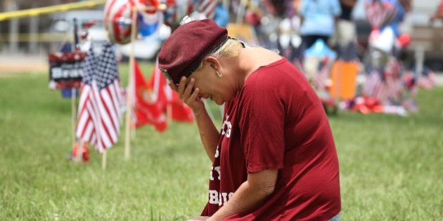 CHATTANOOGA, TN - JULY 17: Laurie Norman is overcome with emotion as she pays her respects to those killed while visiting a memorial placed in front of the Armed Forces Career Center/National Guard Recruitment Office which had been shot up on July 17, 2015 in Chattanooga, Tennessee. According to reports, Mohammod Youssuf Abdulazeez, 24, opened fire on the military recruiting station on July 16th at the strip mall and then drove to an operational support center operated by the U.S. Navy and killed four United States Marines there, more than seven miles away, (Photo by Joe Raedle/Getty Images)