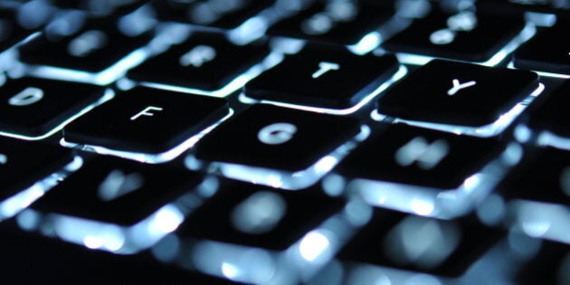 Backlit keyboard of laptop with letter F in focus.