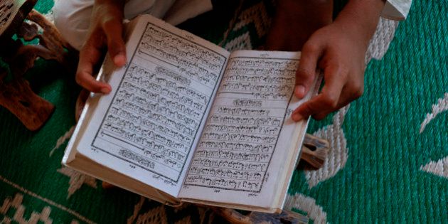 Student reading the Koran in an Islamic school, New Delhi, India