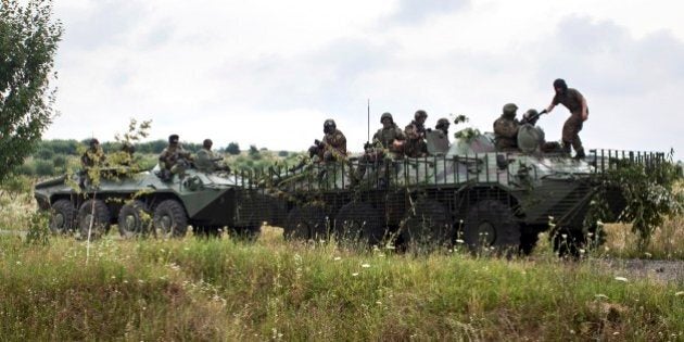 Ukrainian Government forces patrol the area at Bobovysche village near Mukacheve, Ukraine, Monday, July 13, 2015, after two people were killed Saturday in a Right Sector gun-and-grenade attack on police in a western Ukrainian city. Police surrounded gunmen on Saturday in a wooded area of Mukacheve and have been trying to negotiate their surrender since then. (AP Photo/Petro Zadorozhnyy)