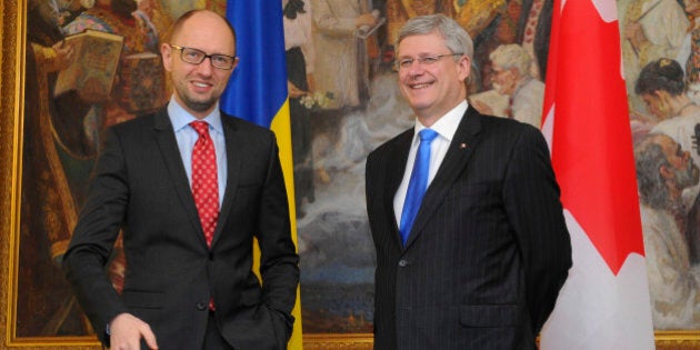 Ukrainian Prime Minister Arseniy Yatsenyuk, right, speaks with Canadian Prime Minister Stephen Harper in Kiev, Ukraine, Saturday, March 22, 2014. World leaders are gathering in Europe for a Nuclear Security Summit March 24-25, with the main topic of discussion expected to be the situation in Ukraine. (AP Photo/Andrew Kravchenko, Pool)