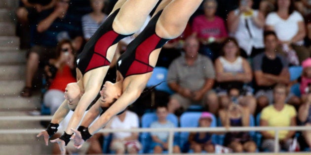 Meaghan Benfeito and Roseline Filion of Canada compete during the women's synchronized 10-meter platform diving event at the Pan Am Games Monday, July 13, 2015, in Toronto. The pair won the gold medal in the event. (AP Photo/Mark Humphrey)