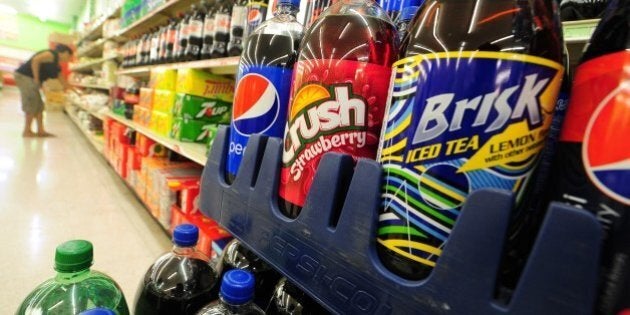 A woman shops for food items near a display of bottes of soda at a superrmarket in Rosemead, California on June 18, 2014, a day after a bill in California that would require soft drinks to have health warning labels failed to clear a key committee. Under the measure, sugary drinks sold in the most populous US state would have had to carry a label with a warning that sugar contributes to obesity, diabetes and tooth decay and the legislation, which would have been the first of its kind in the United States, passed the state Senate in May, but on it failed to win enough votes in the health commission of the California State Assembly on June 17, the Los Angeles Times reported. AFP PHOTO/Frederic J. BROWN (Photo credit should read FREDERIC J. BROWN/AFP/Getty Images)